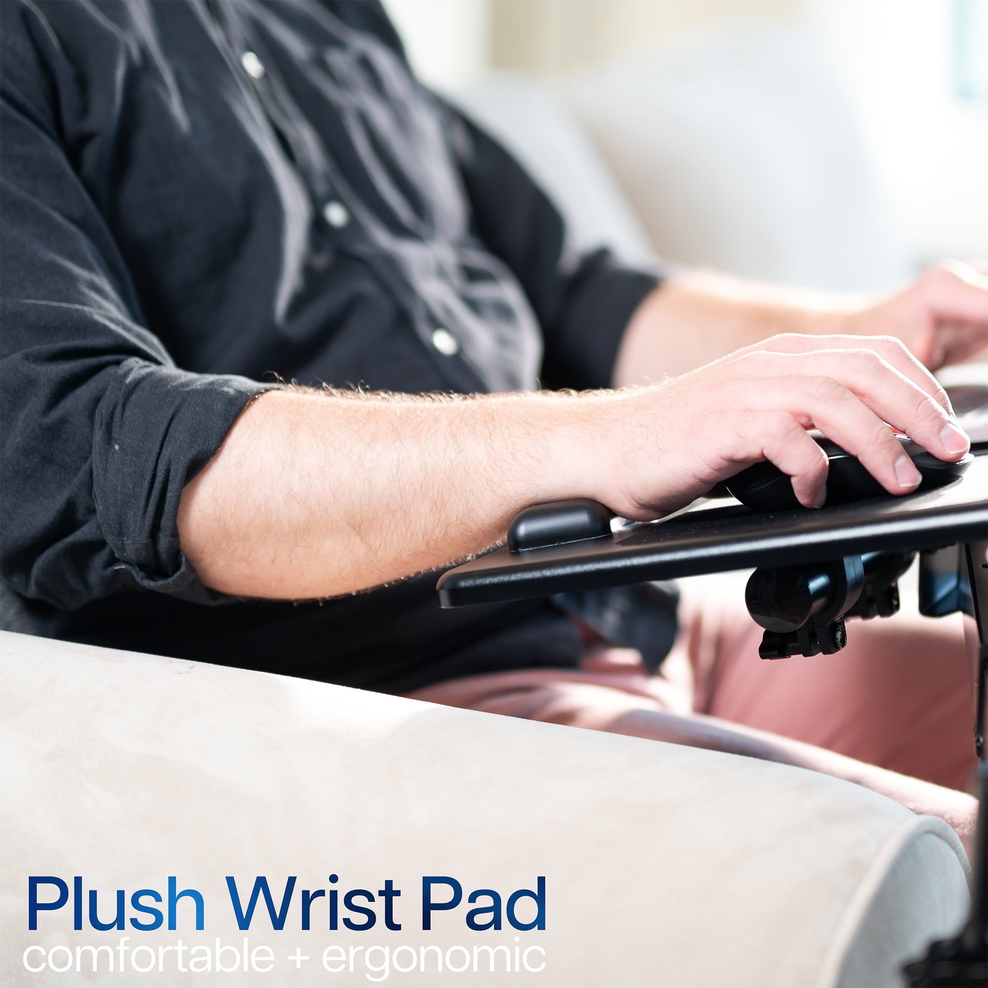 Person using a computer with a plush wrist pad on a blurred background