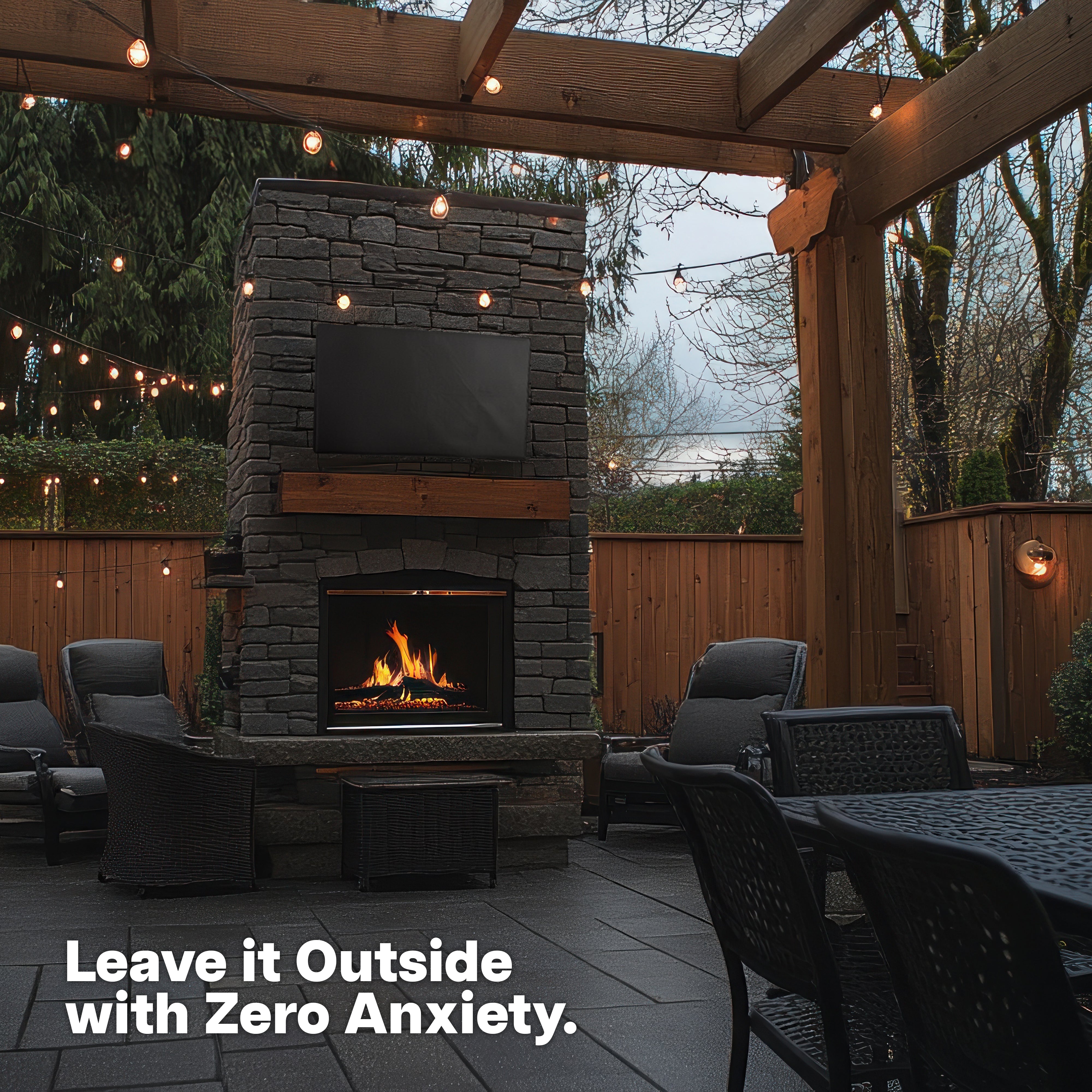 TV with cover on stone fireplace in outdoor patio.