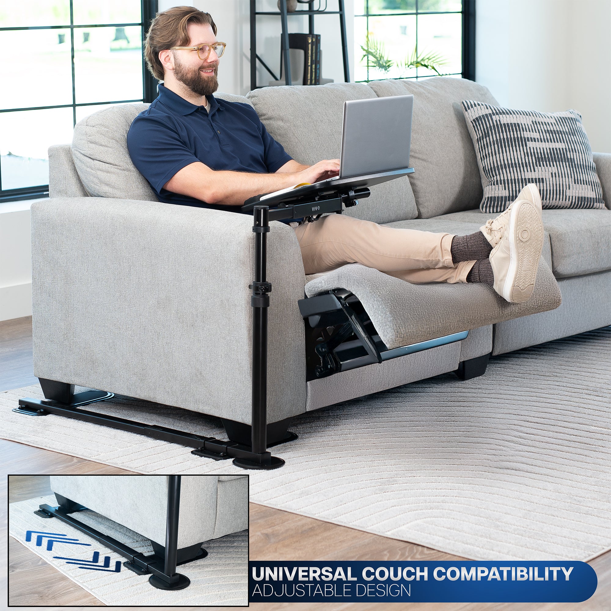 Man using a laptop on an adjustable couch stand in a living room.
