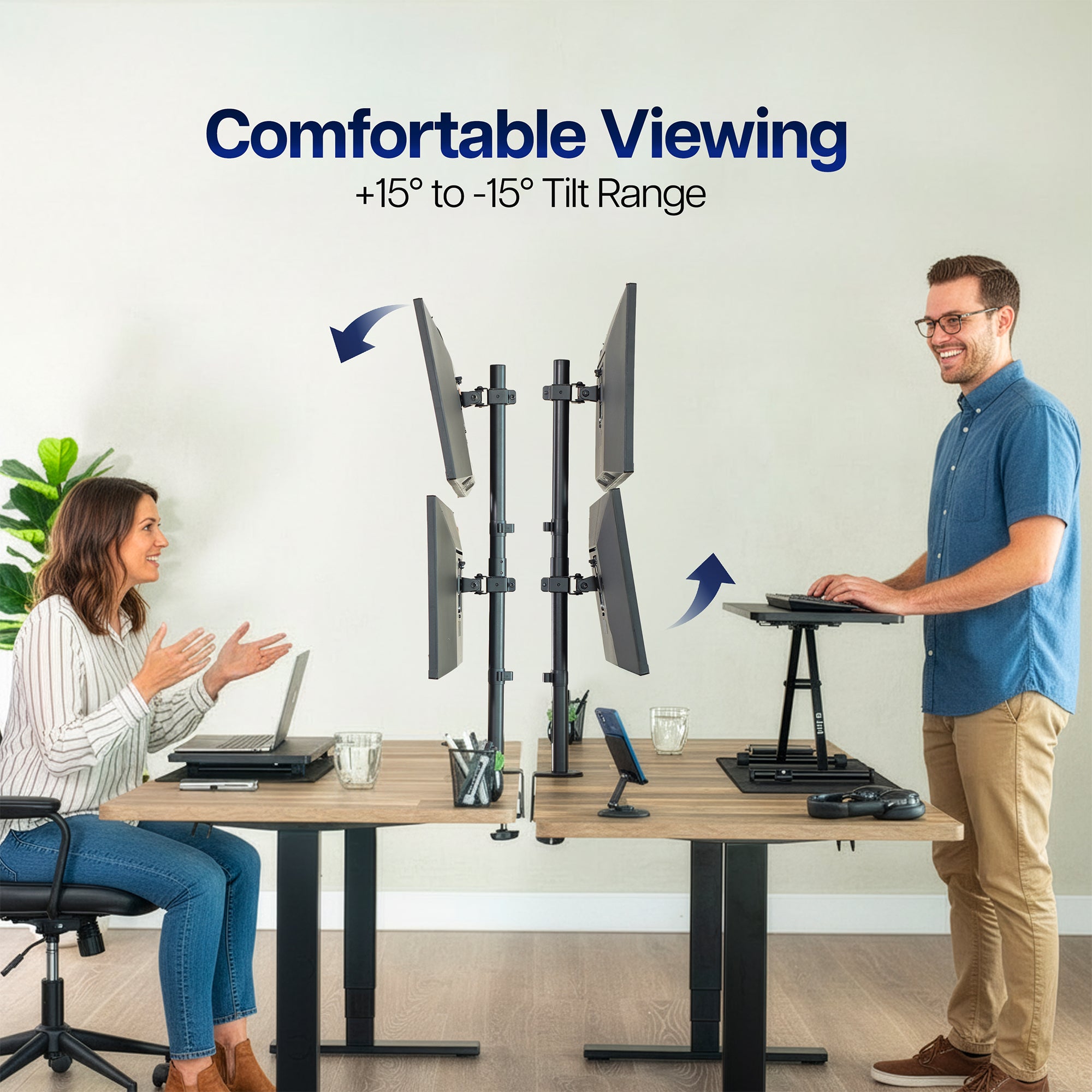 Two people at a desk with adjustable monitors and standing desk, emphasizing comfortable viewing angles.