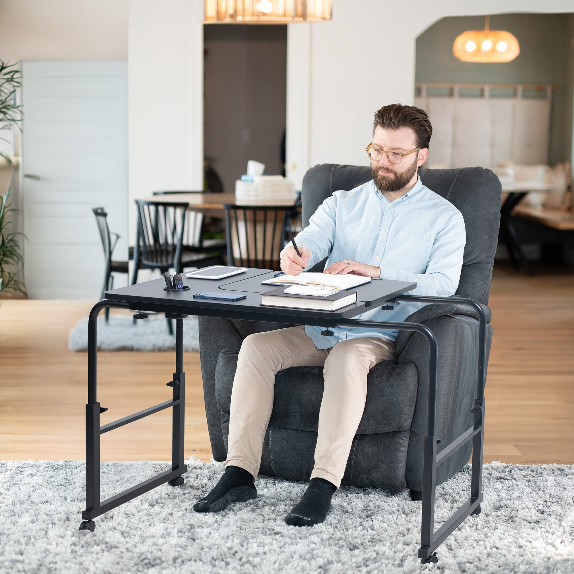 Man sitting in a recliner chair with a small table / desk in a home office setting.