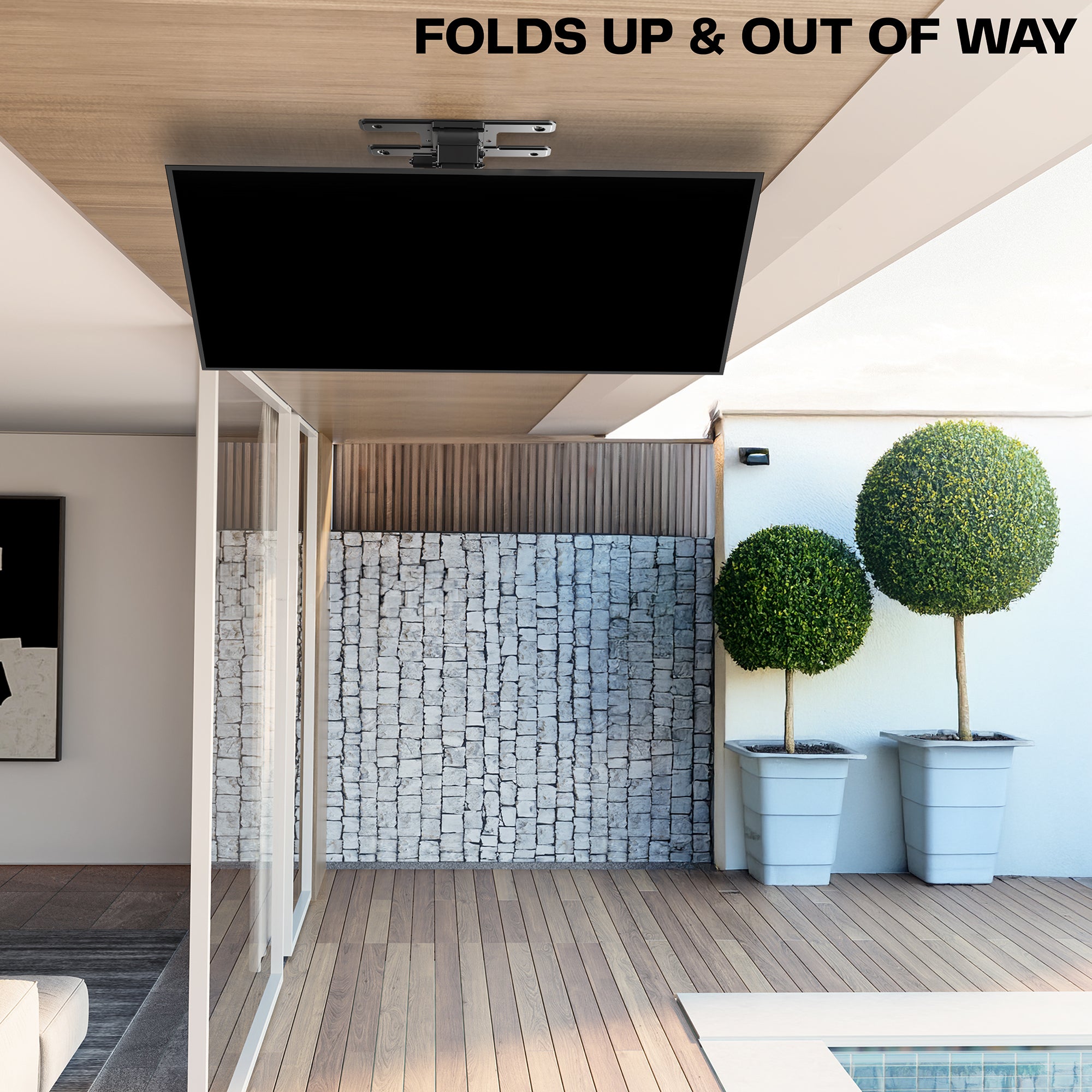 A black electric flip down/swivel ceiling TV mount in a minimalist backyard scene.