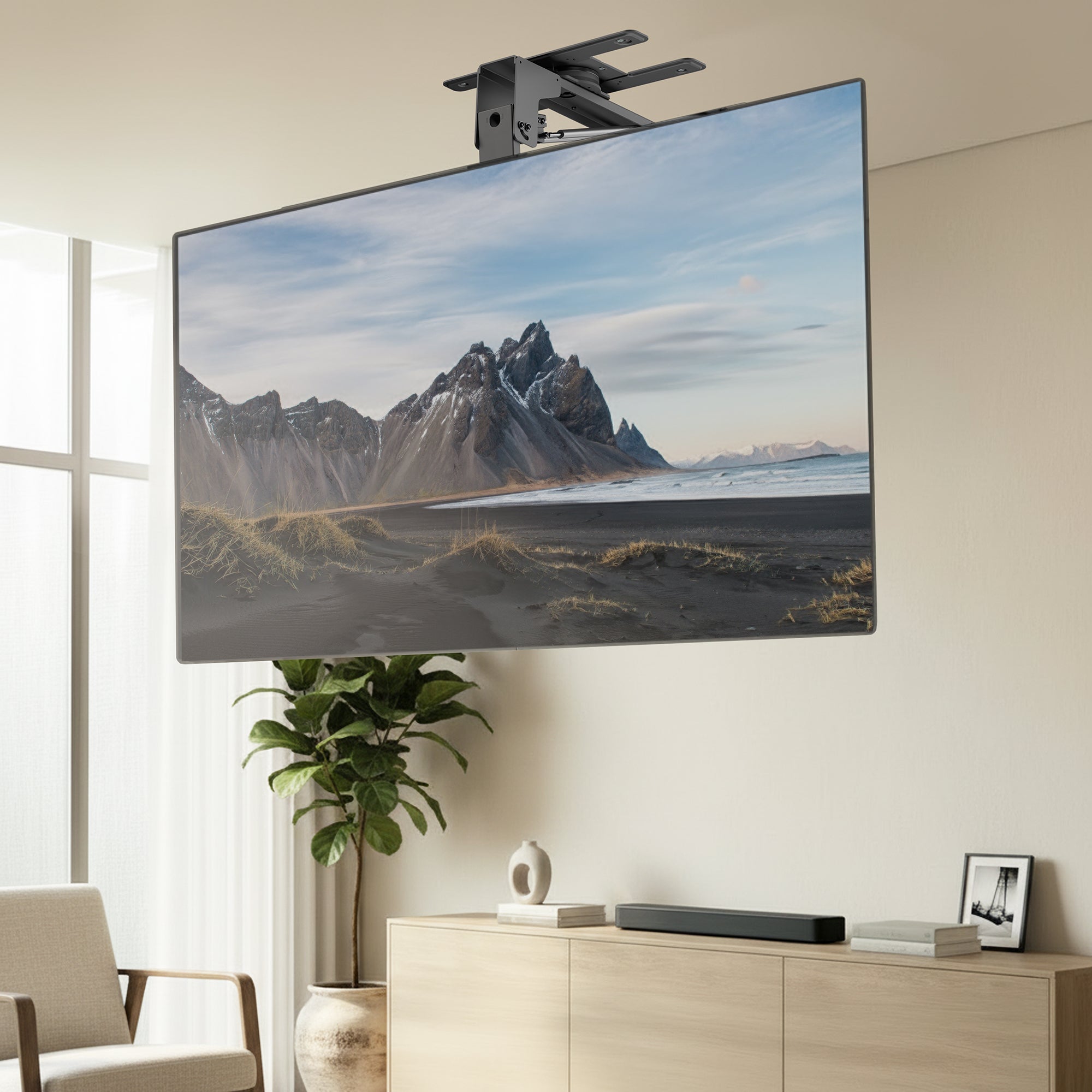 TV mounted on a Manual Flip Down TV Ceiling Mount displaying a mountain landscape in a living room.