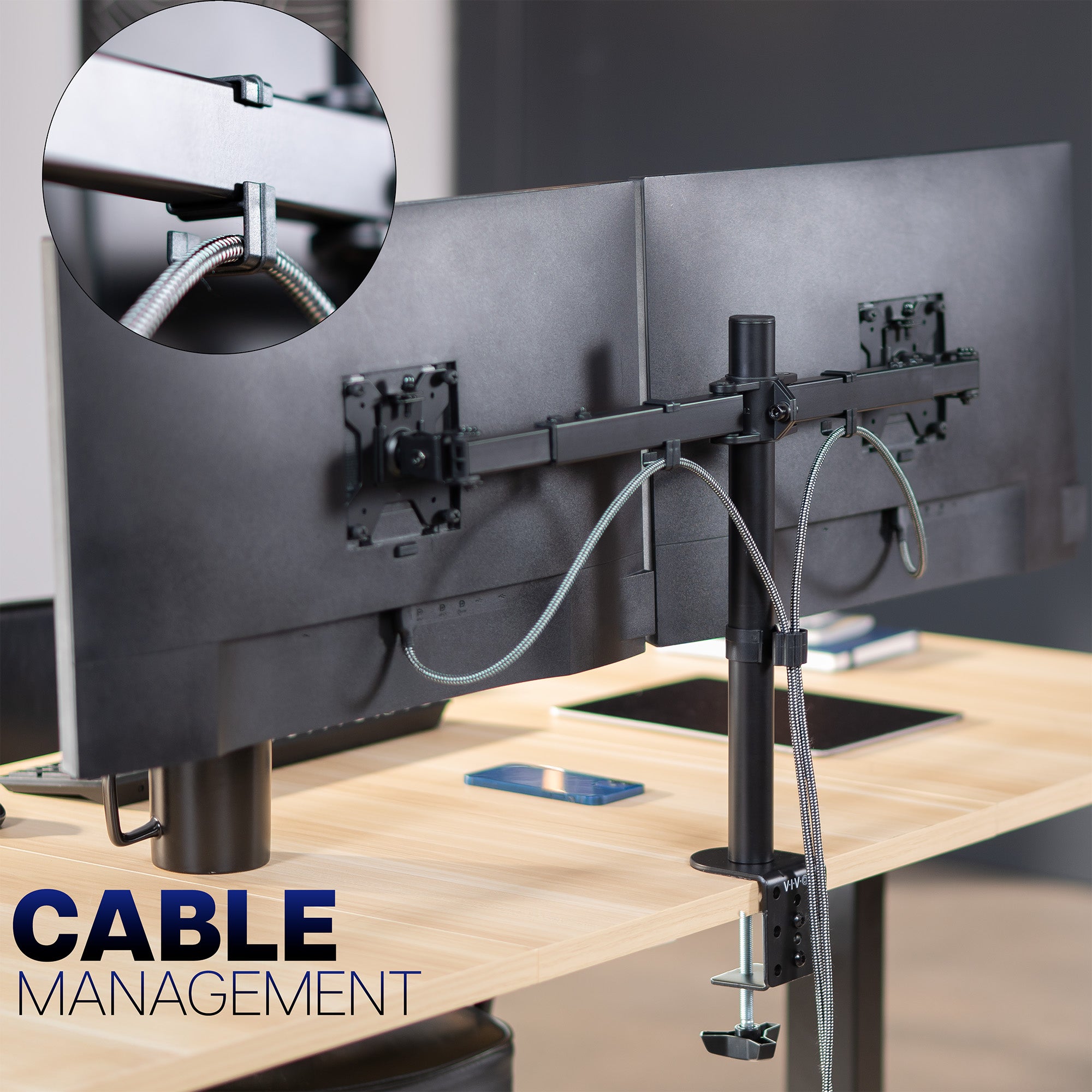 Monitor stand with cable management system on a desk, featuring close-up of cable clips.