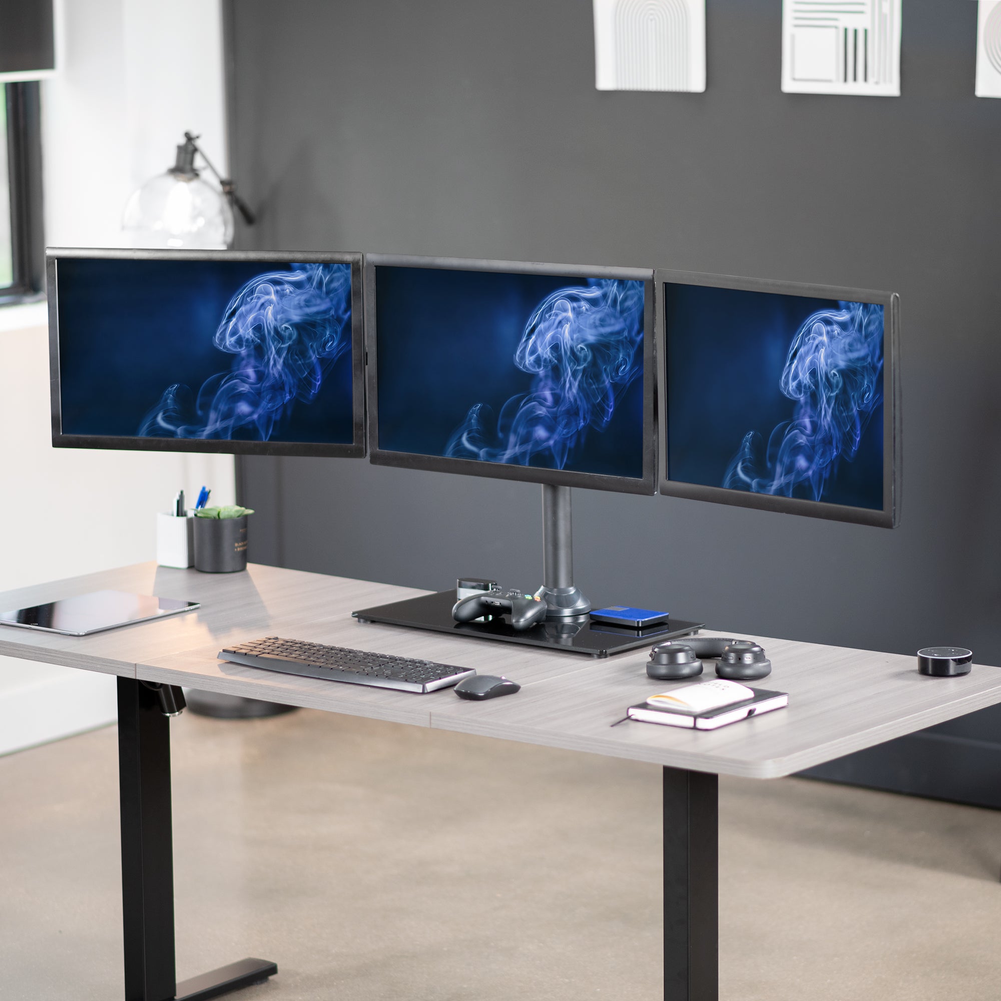 Triple Monitor Desk Stand on desk in office space.