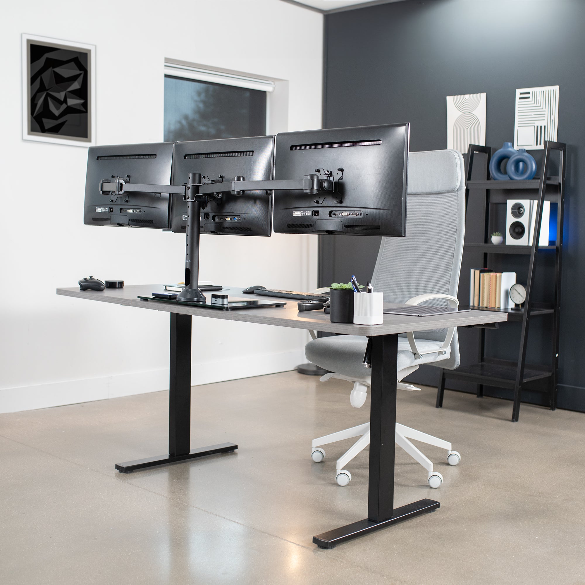 Triple Monitor Desk Stand on desk in office setting.