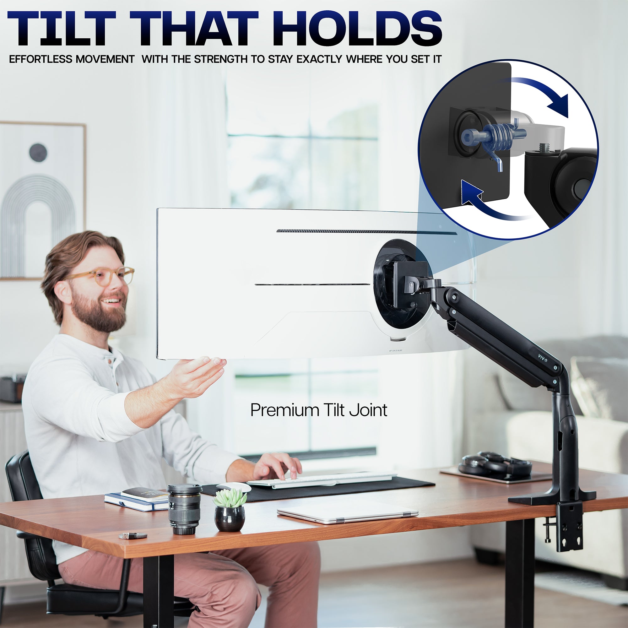 Man sitting at a desk with a monitor on a adjustable arm, emphasizing the tilt feature.