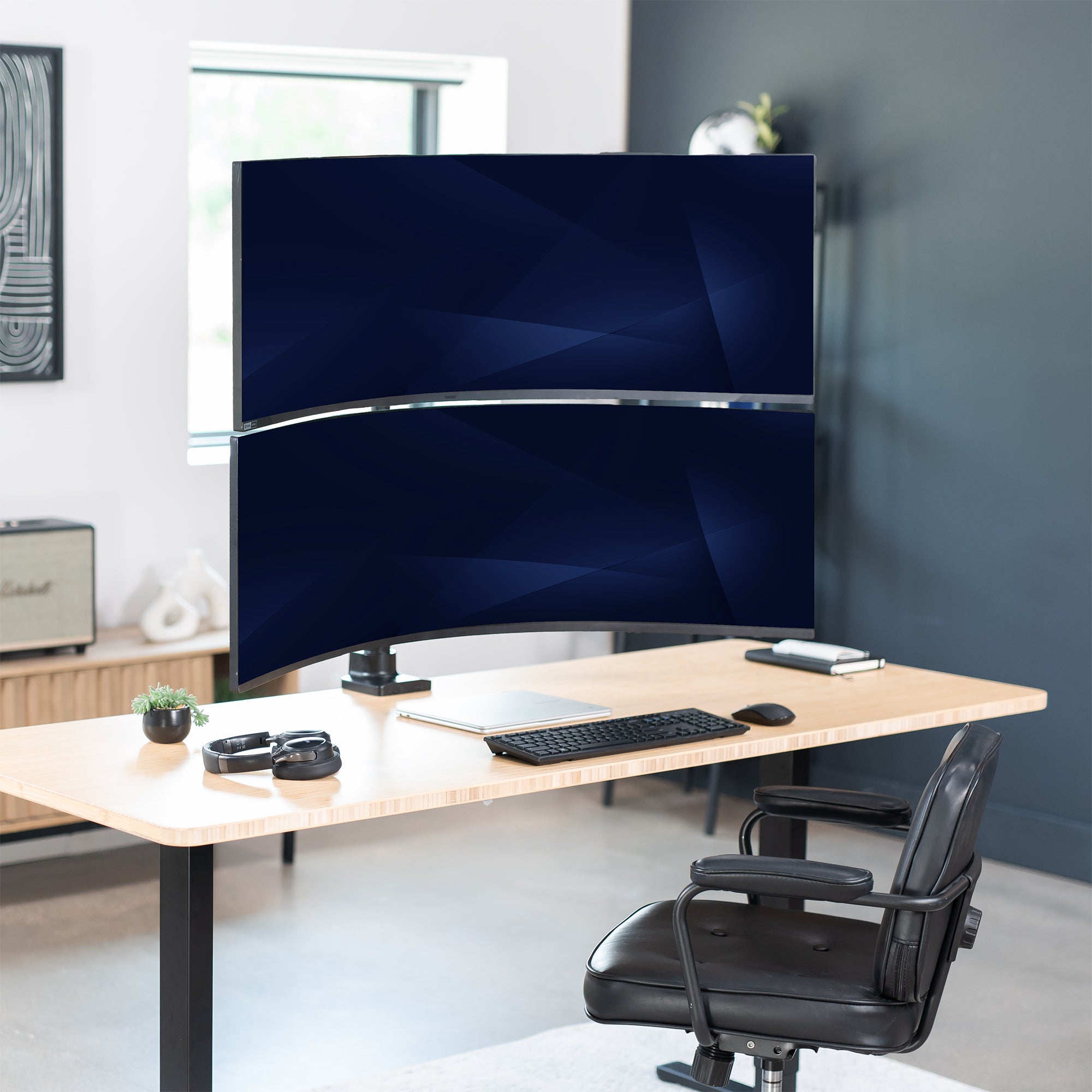 Modern office setup with a dual monitor setup on a desk, chair, and decor.