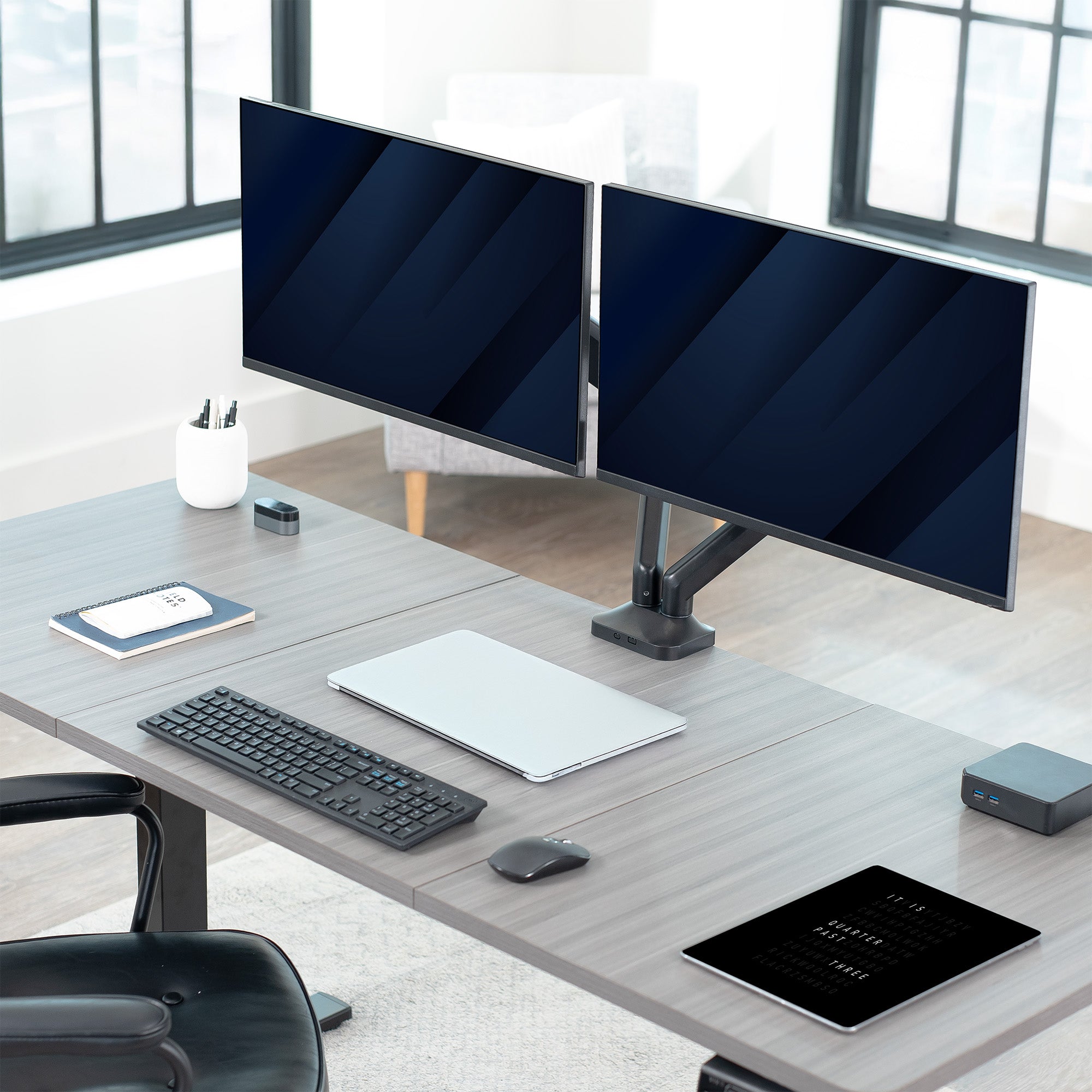 Modern office desk setup with dual monitors, keyboard, mouse, and tablet.