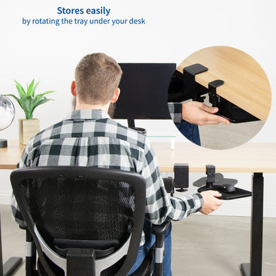 A man at a desk pulling out a rotating mouse pad for an ergonomic office setup.