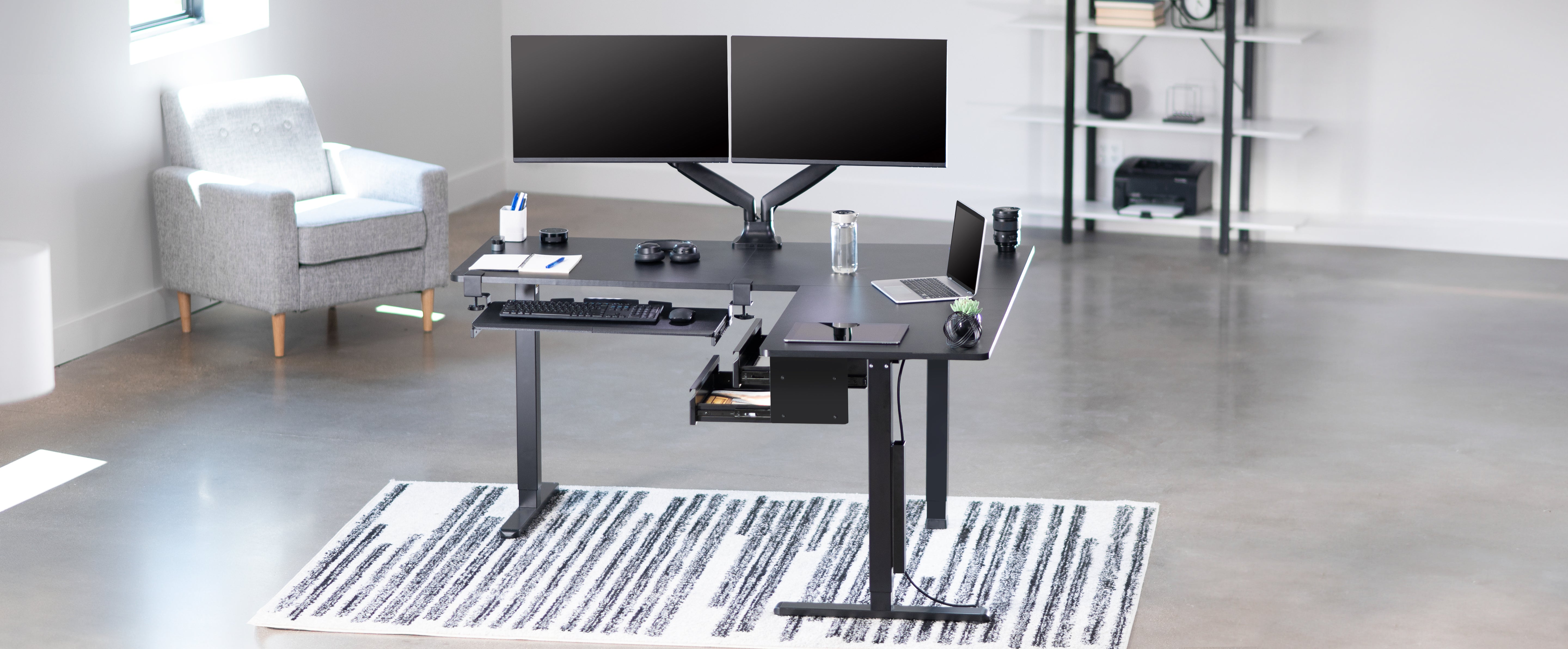 Sit to stand desk in office space with desk accessories