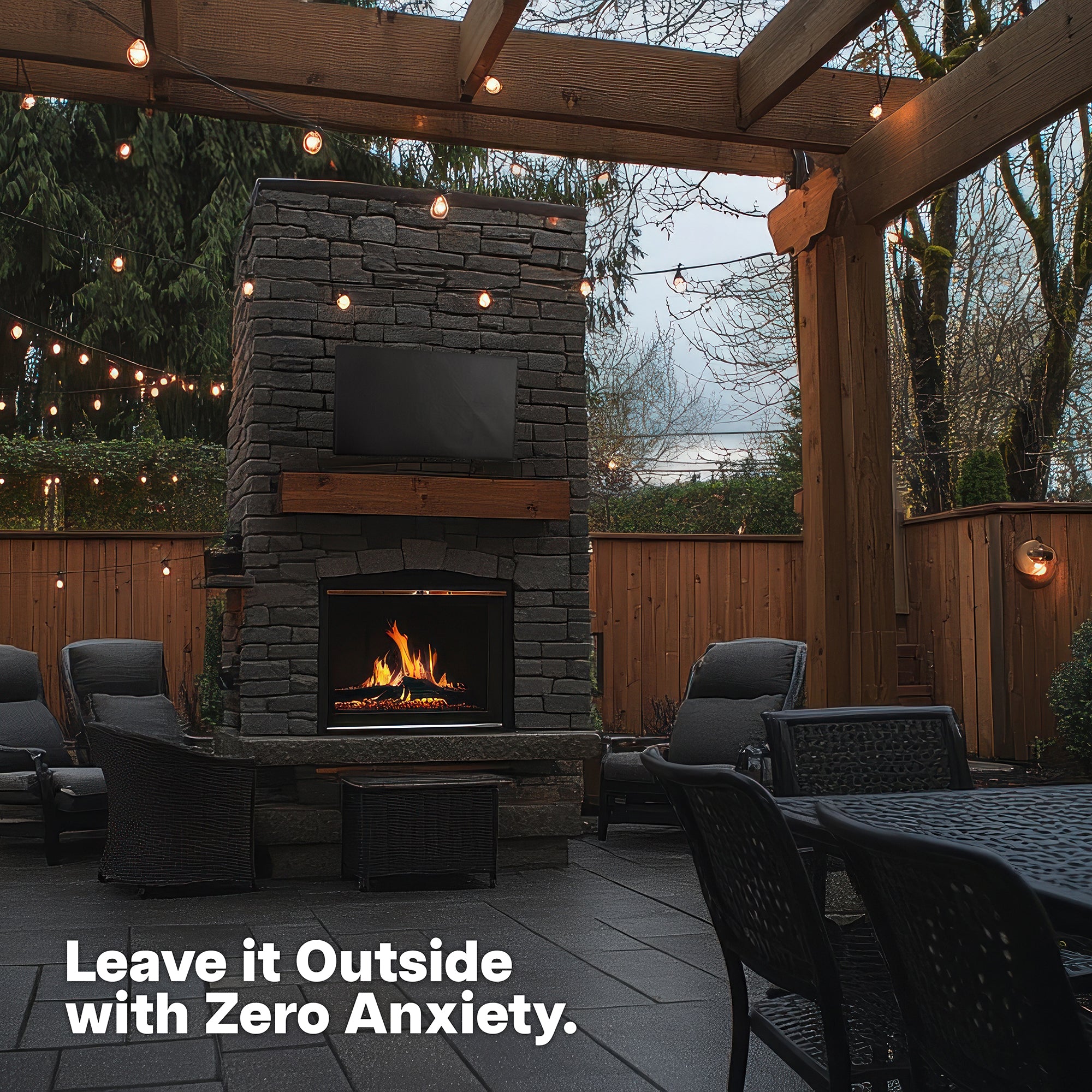 Outdoor patio with stone fireplace with a TV with TV protective cover featuring text 'Leave it Outside with Zero Anxiety'.