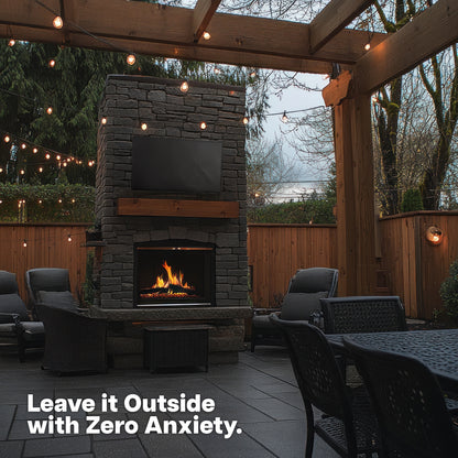 TV with cover on stone fireplace in outdoor patio.