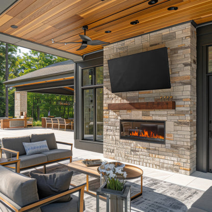 TV with TV cover on stone fireplace in outdoor setting.
