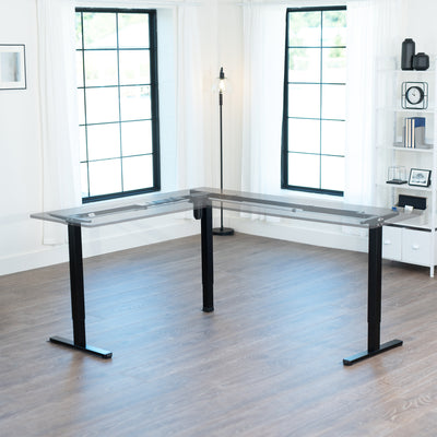 Modern L-shaped desk frame in a bright room with large windows