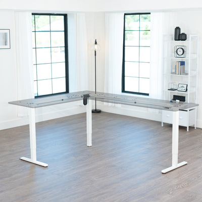 Modern L-shaped desk in a bright room with large windows.