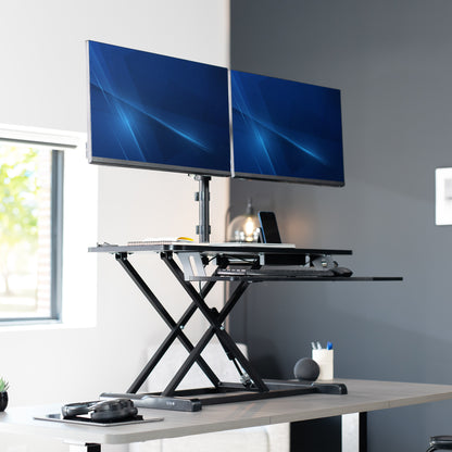 36 inch height adjustable desk riser with articulating mechanical dual monitor mount.