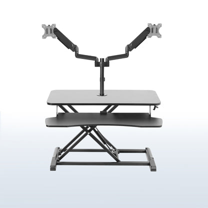 Height adjustable desk riser with articulating pneumatic dual monitor mount.