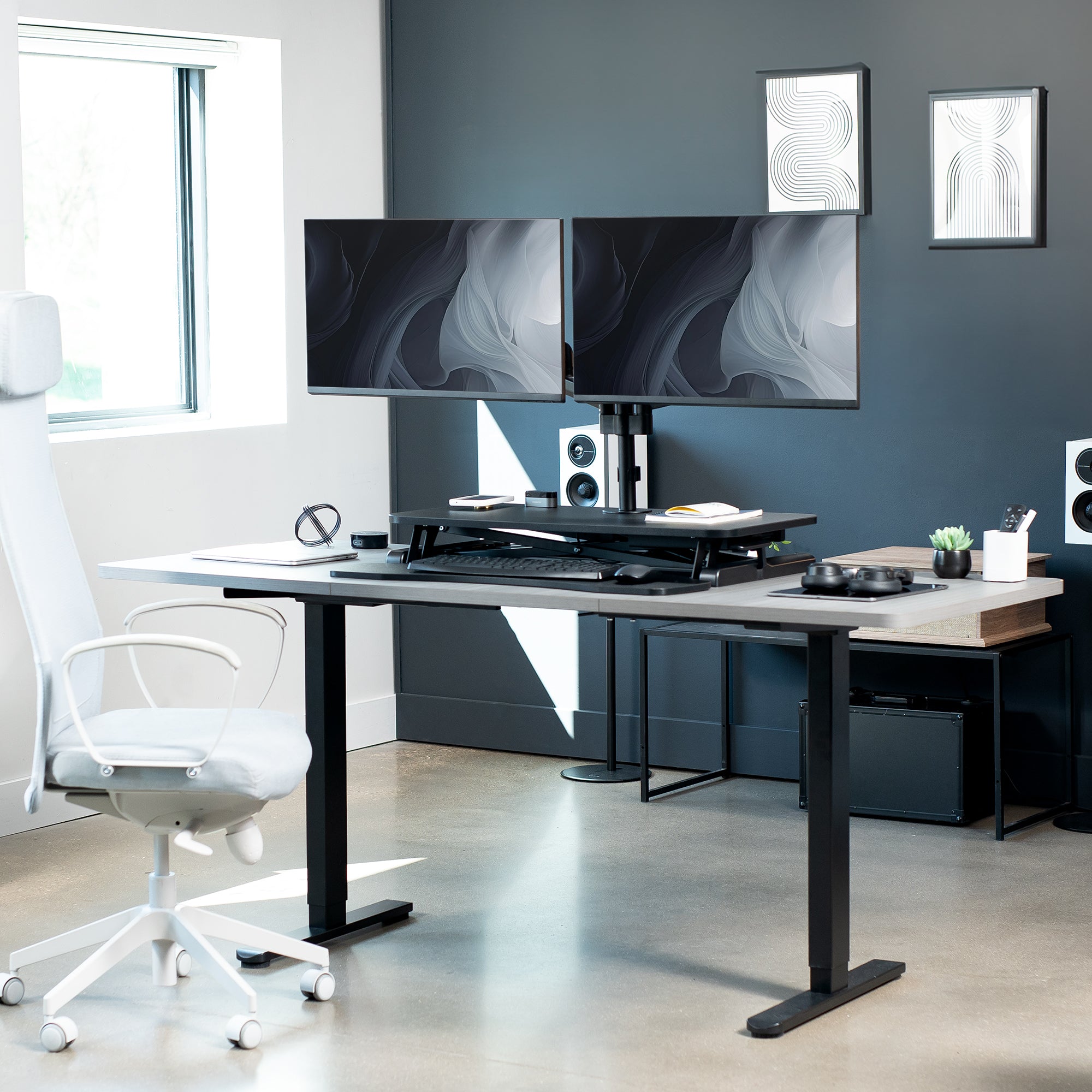 Height adjustable desk riser with articulating pneumatic dual monitor mount.