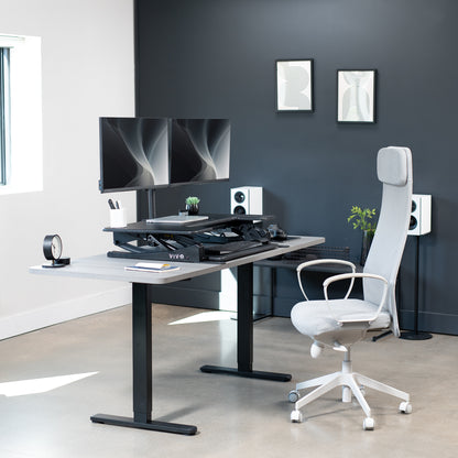 Height adjustable desk riser with articulating dual monitor mount.