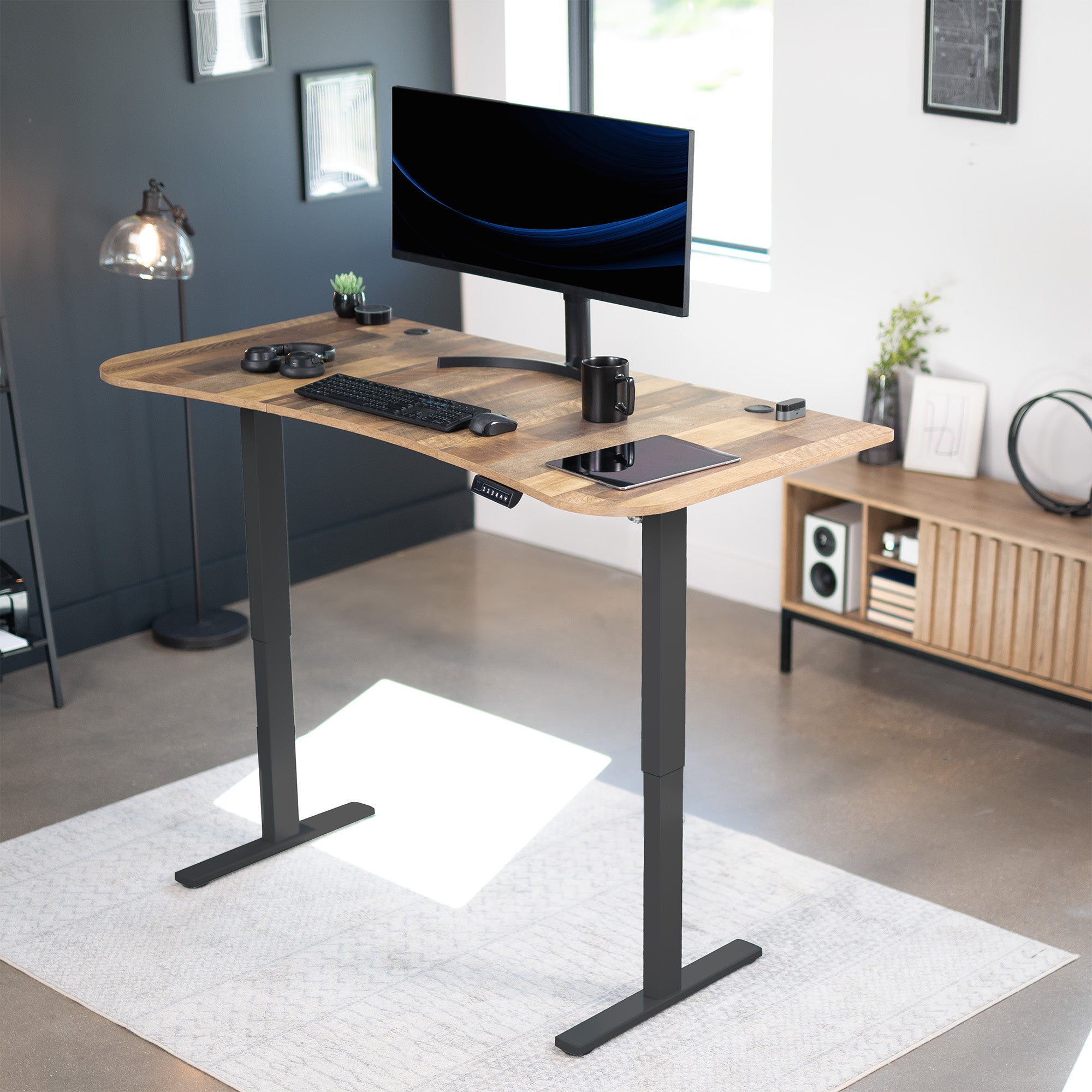 Sit to stand height adjustable electric desk with push button memory controller for ergonomic office workstation.