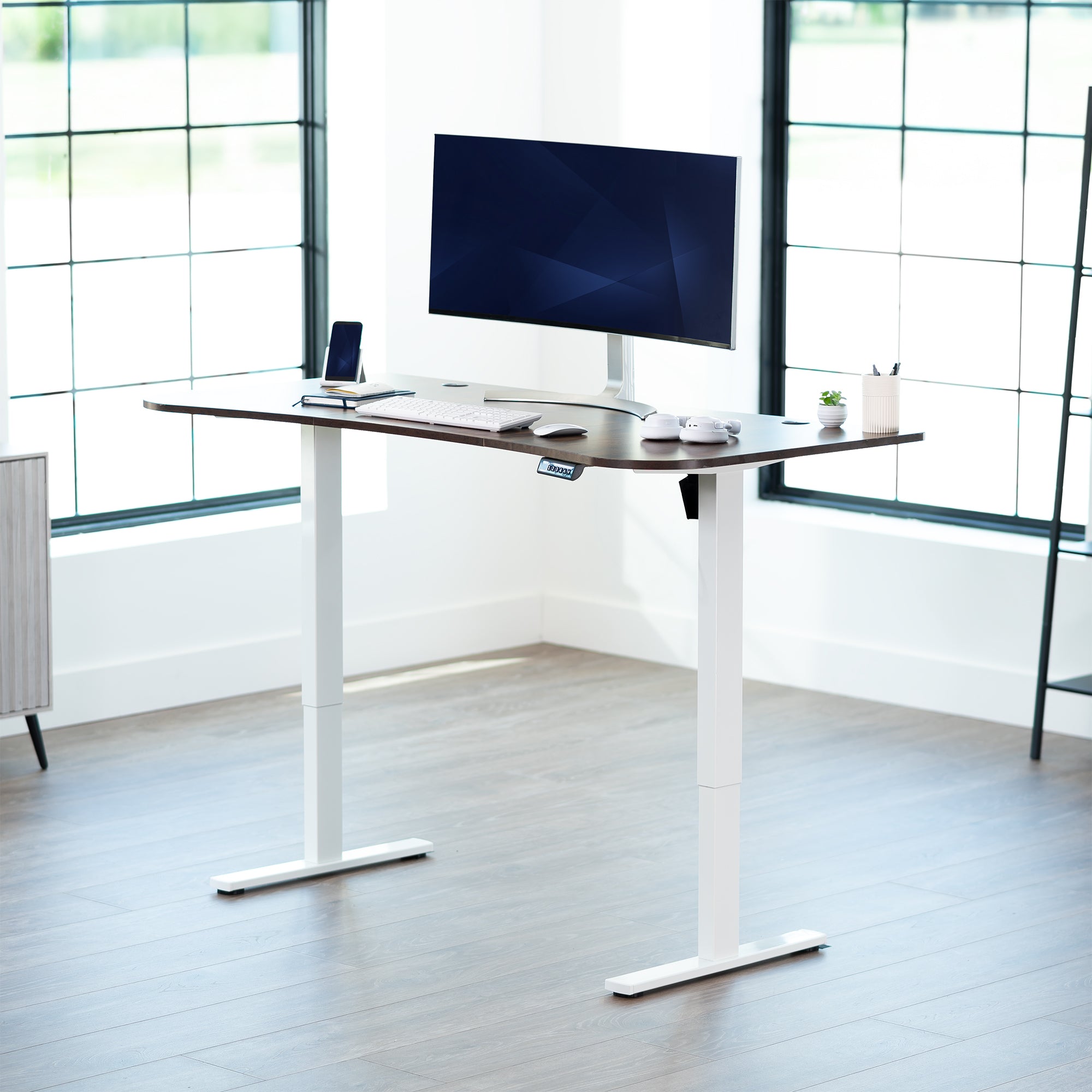 Rustic, vintage brown top white frame, electric, sit to stand, height adjustable desk in office setting.