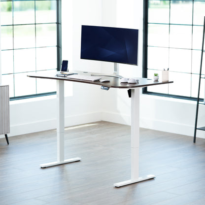 Rustic, vintage brown top white frame, electric, sit to stand, height adjustable desk in office setting.