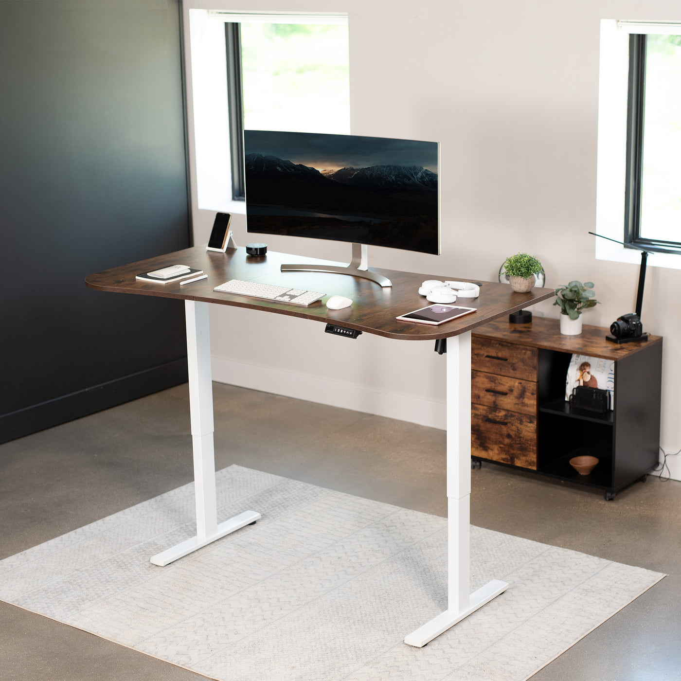 Rustic sit to stand height adjustable electric desk with push button memory controller for ergonomic office workstation.