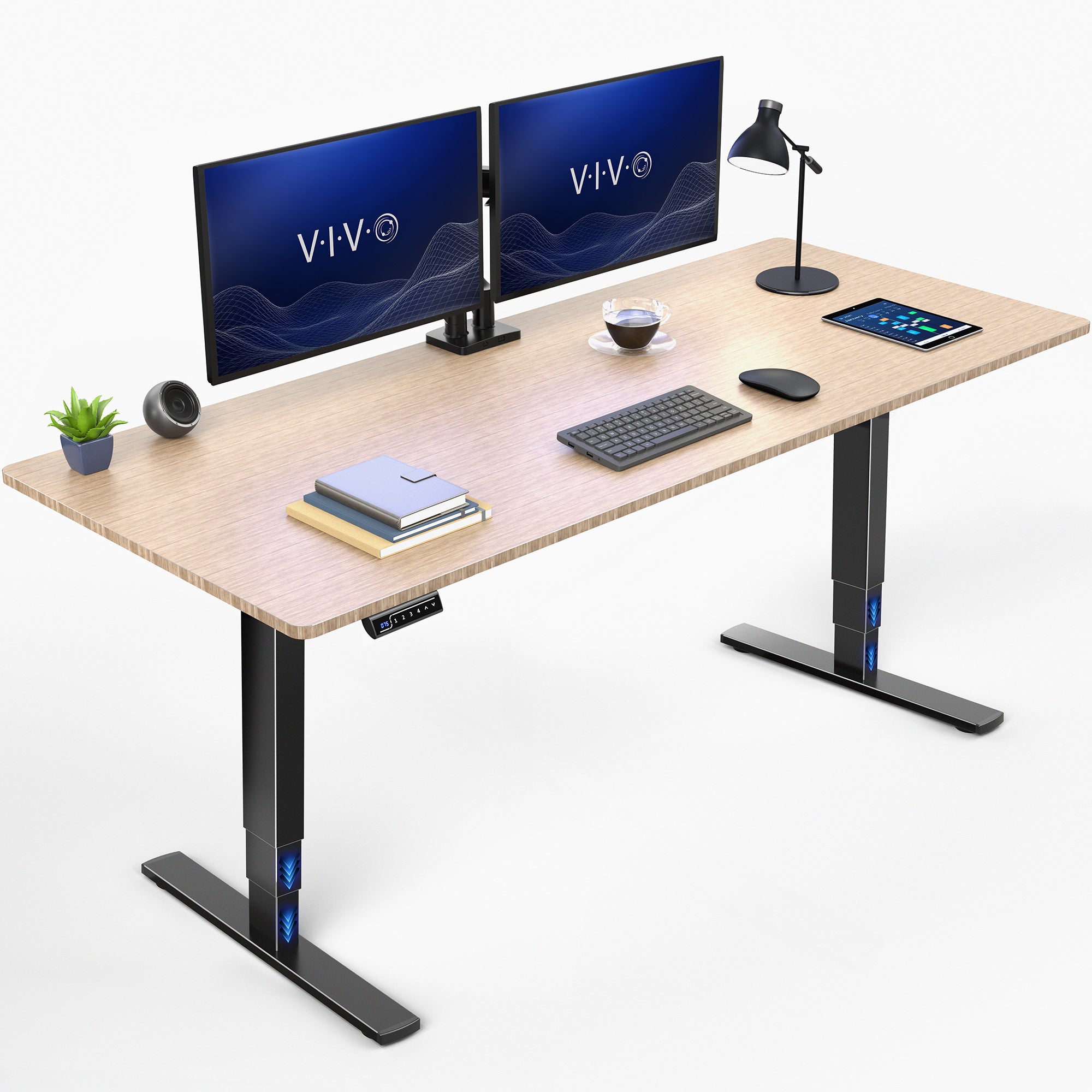 A bamboo adjustable standing desk top and black metal legs, shown with a dual monitor setup, keyboard, mouse, tablet, lamp, books, and a small plant on a clean white background.