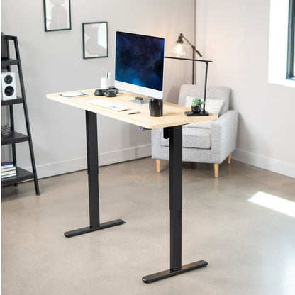 Modern office setup with a standing desk, computer monitor, and chair.