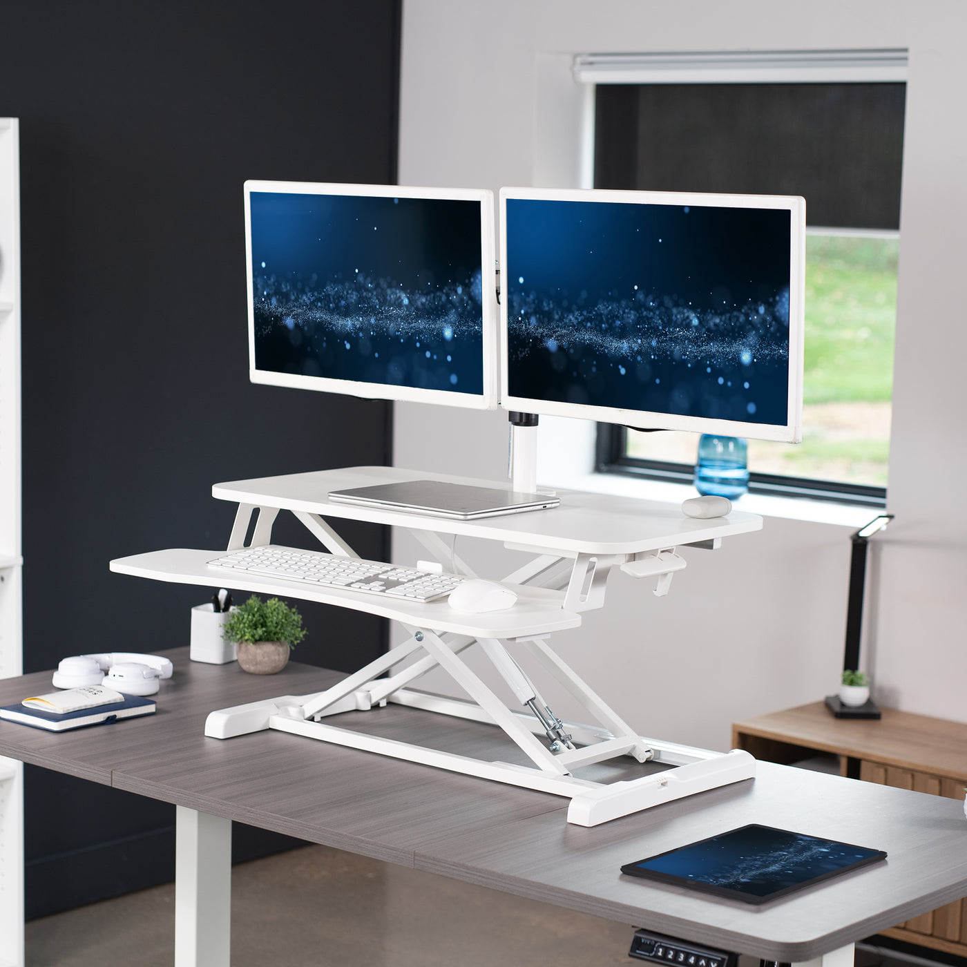 Sturdy height adjustable desk converter with articulating dual monitor mount.