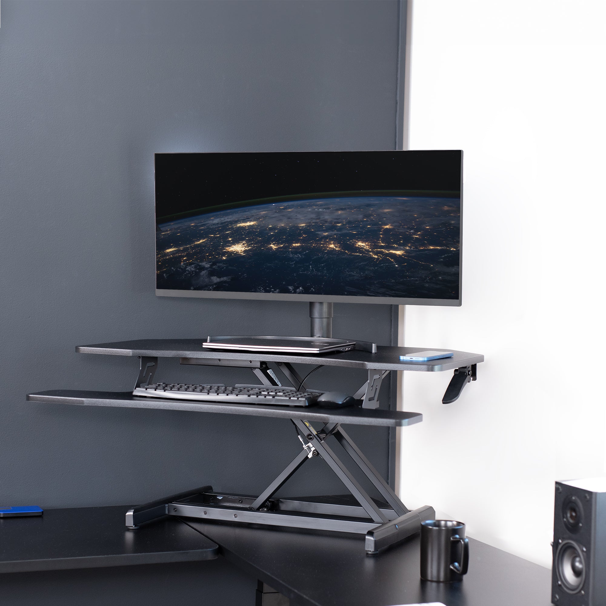 Heavy-duty height adjustable desk converter monitor riser for corner desk workstation.