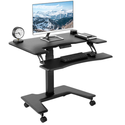 Electric mobile compact desk provides a height adjustable workstation for home or the office, featuring a 2 tier design for your screen and keyboard tray.