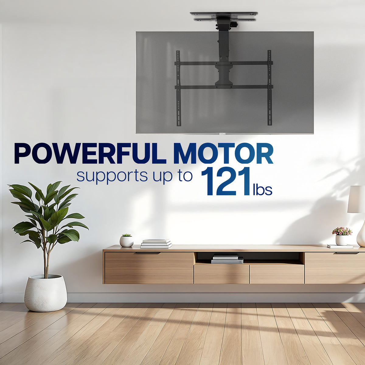 A ceiling-mounted TV bracket shown in a modern living room setting, with large text reading 'POWERFUL MOTOR supports up to 121 lbs' and a floating wood media console below.