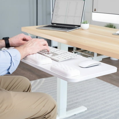 Person using a keyboard on a white premium under desk keyboard tray in office setting