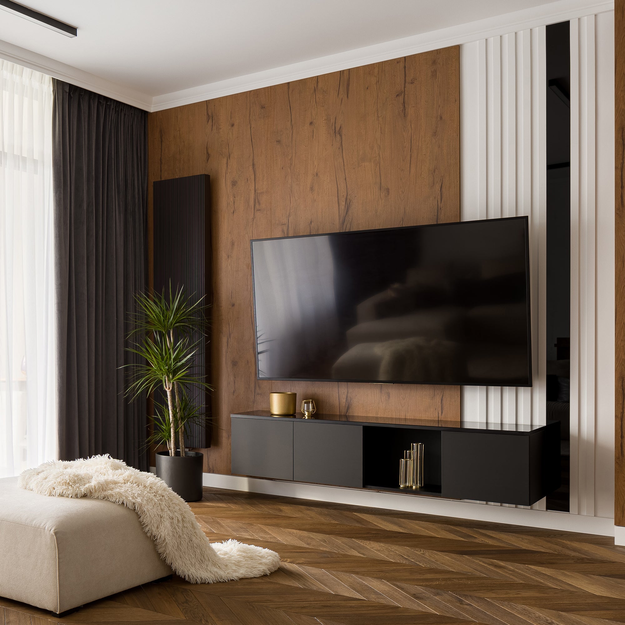 Modern living room with a large TV mounted on a wooden wall.
