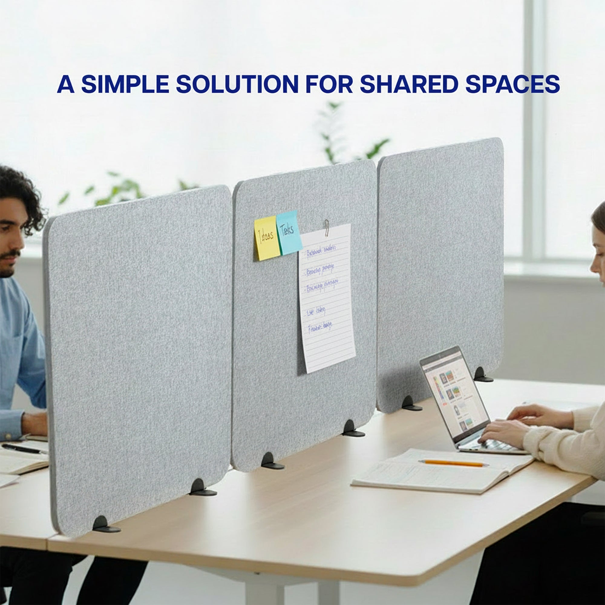 Gray desk privacy panel with people working at a table in an office setting.