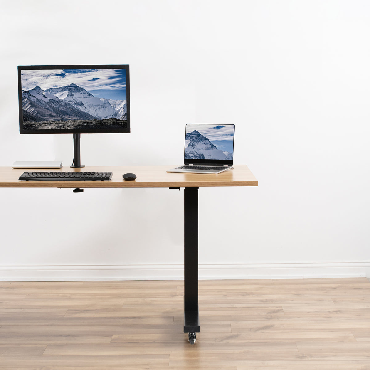 Adjustable height desk with computer setup on a white background