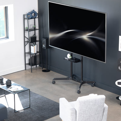 Mobile TV mount cart with media shelf and locking wheels. Stand features height adjustment, articulation, and a built-in cable management system.