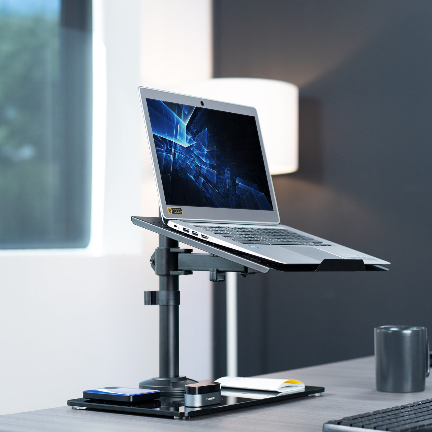 Freestanding laptop stand with elegant glass base for ergonomic viewing and adjustable placement.
