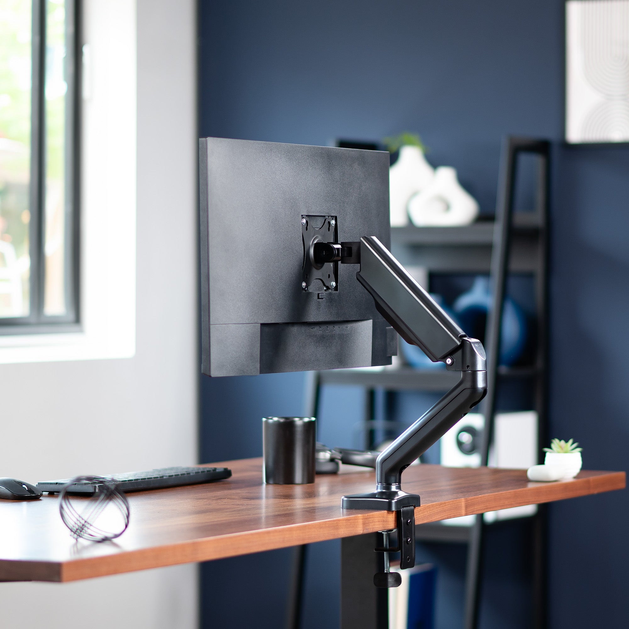 Sturdy clamp-on pneumatic arm single monitor desk mount with USB ports and audio ports, articulation, height adjustment, and cable management.