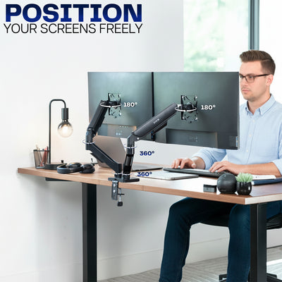 Person using a computer setup with a flexible arm dual monitor stand in a modern office.