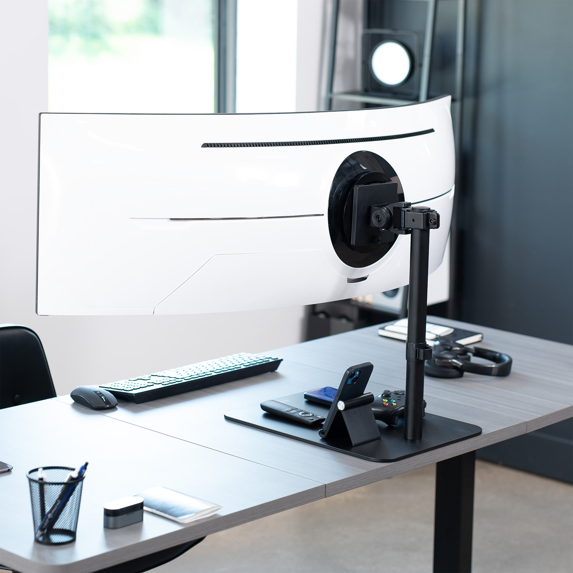 Modern office desk setup with computer monitor, keyboard, mouse, and phone on a desk.