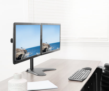 Two computer monitors on a desk with a keyboard and mouse, displaying a scenic view.