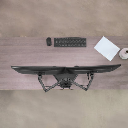 Desk setup with dual monitor, keyboard, mouse, and paper on a wooden desk.