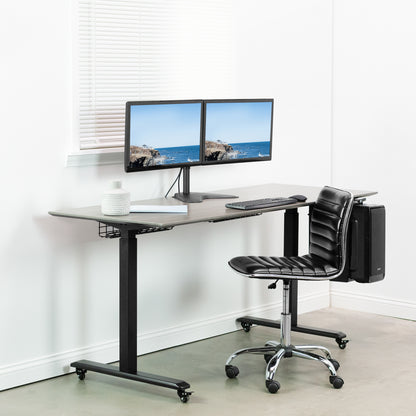 Modern office setup with a adjustable desk, dual monitors, and a black chair.