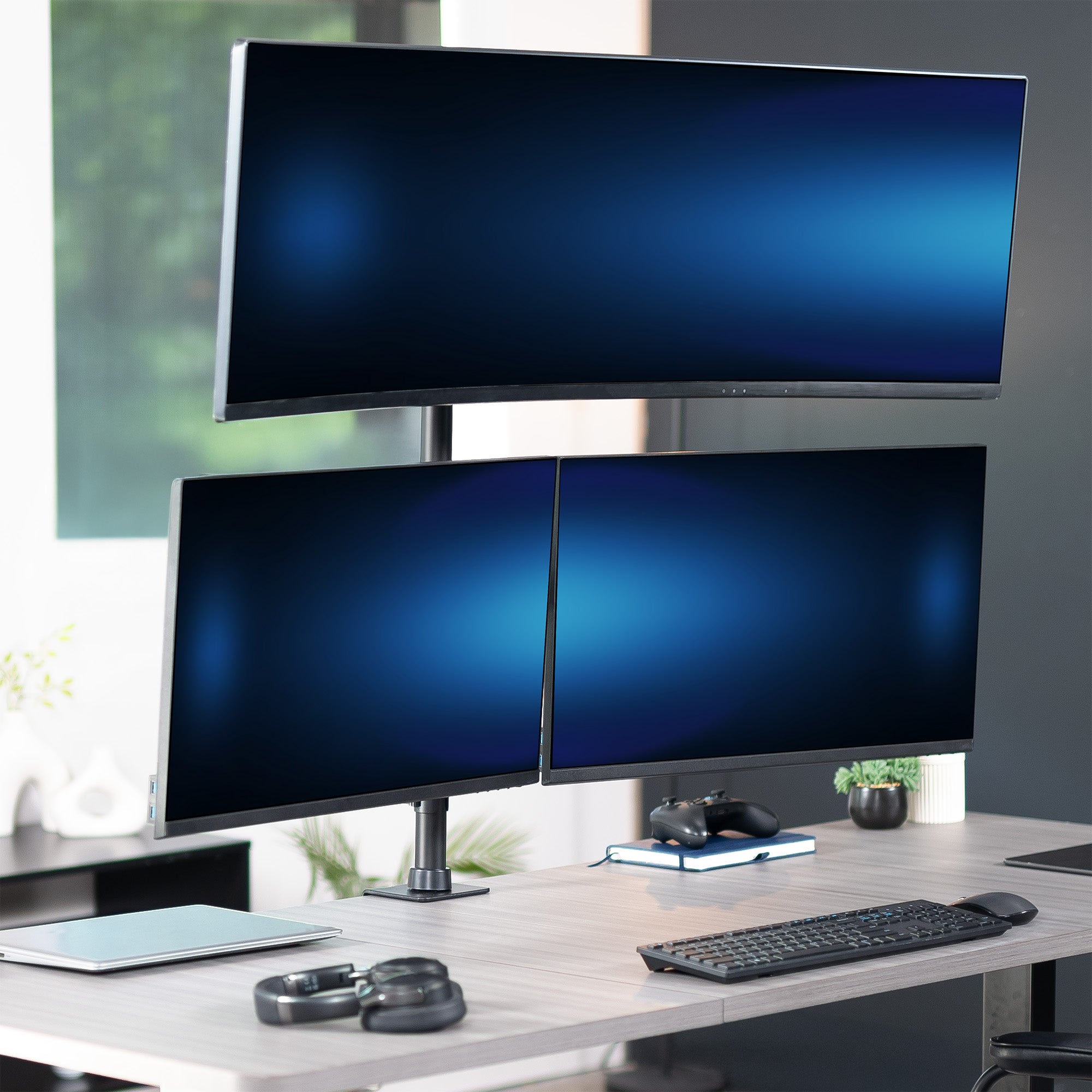 Three computer monitors on a desk with a keyboard and mouse.