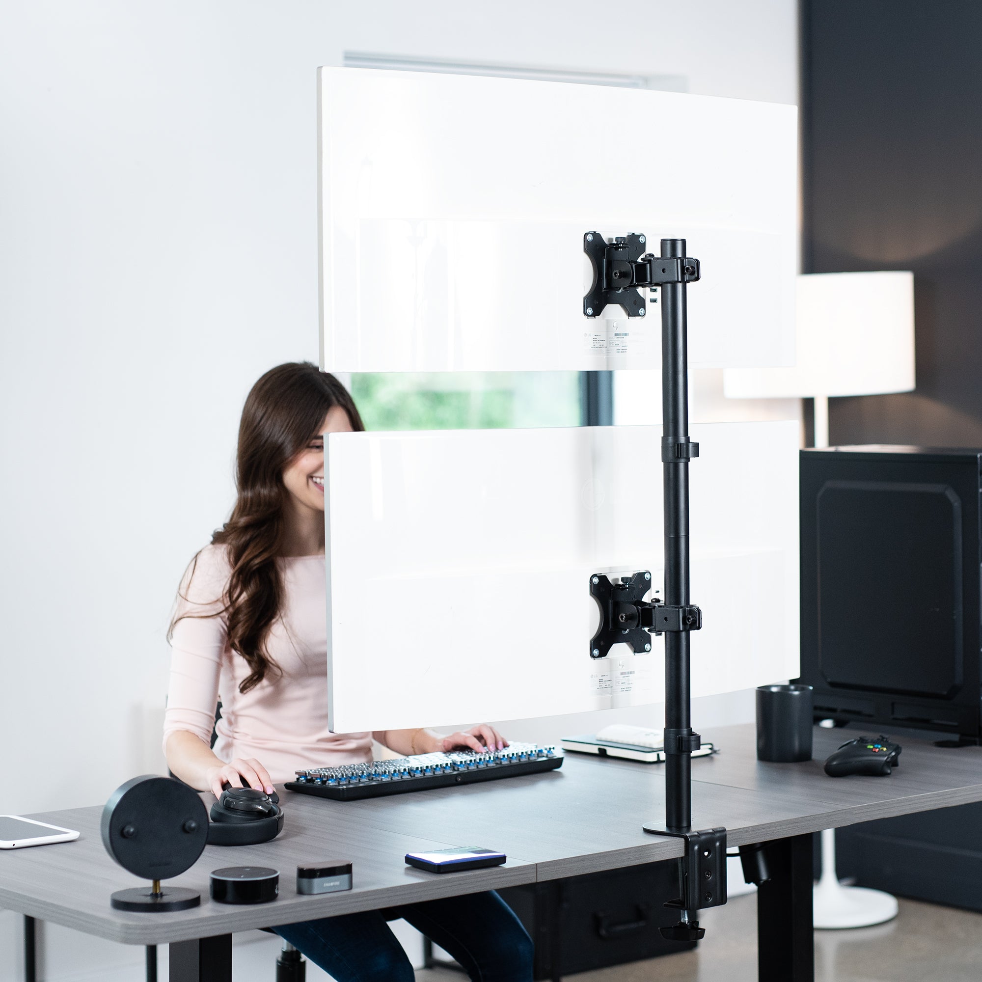 Dual Ultrawide Vertical Monitor Desk Mount elevates 2 large screens in a vertically stacked array to save desk space and create comfortable viewing angles.