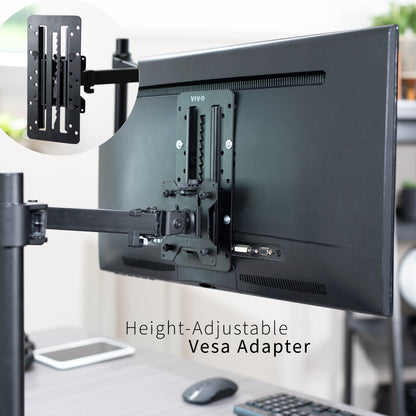 Height-adjustable Vesa adapter attached to a monitor on a desk with office background
