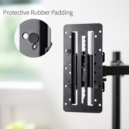 Close-up of a VESA adapter mount with protective rubber padding on a blurred background